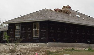 The roofing shingles have been delivered to the site and have been placed on top of the roof.