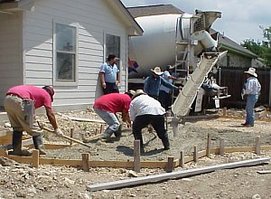 The workmen are beginning to place and level the concrete for the patio.