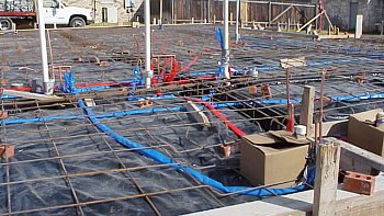 Installation of the copper plumbing lines under the rebar above the plastic.