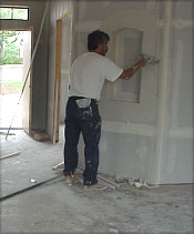 A workman taping and floating the walls...