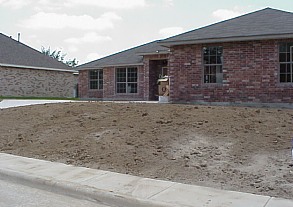 The land has been graded for drainage, and the topsoil has been distributed.