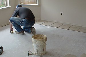 A workman is measuring the floor,