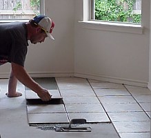 In this picture, the worker is setting the tile.