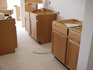 The first cabinets are installed in the kitchen.